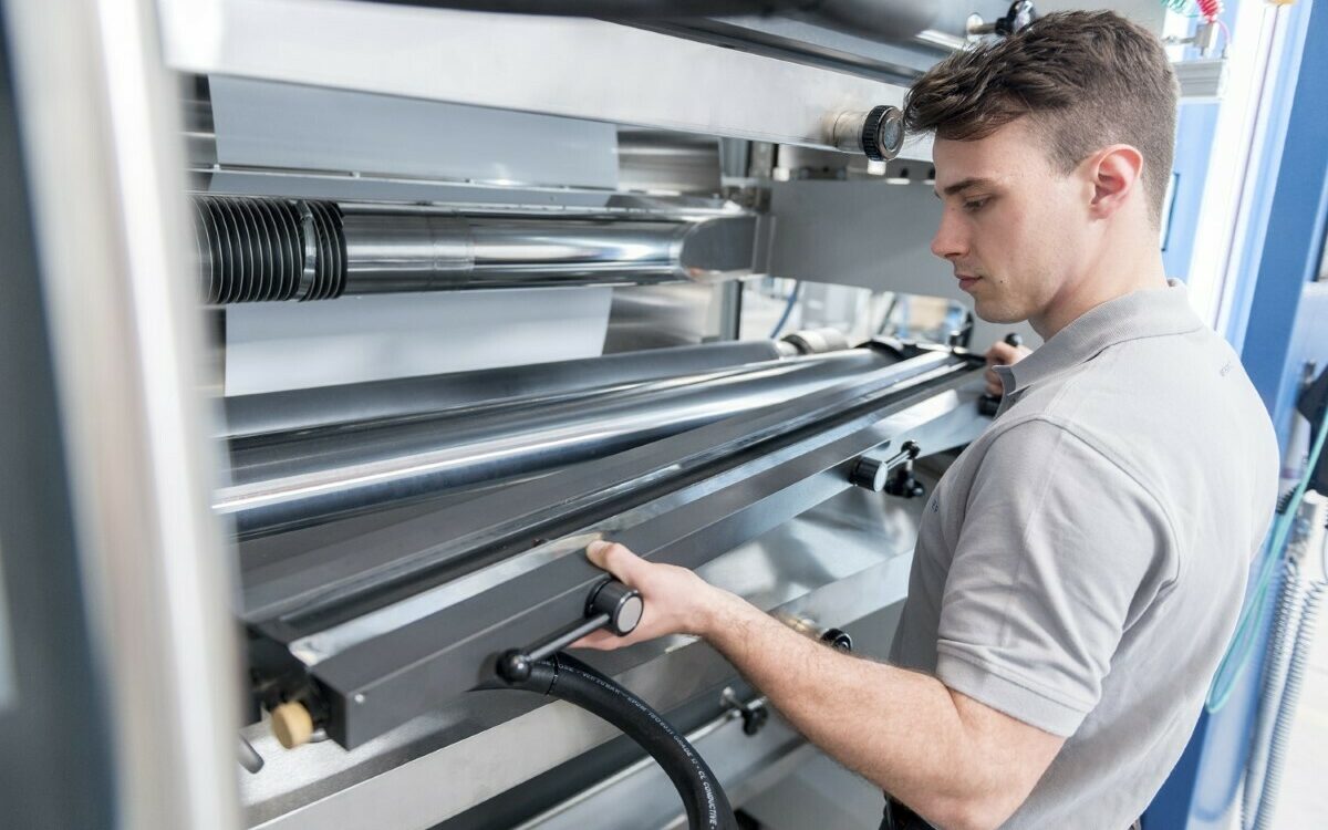 Ein Mitarbeiter von Koenig&Bauer steht vor einer Maschine Ein Mitarbeiter von Koenig&Bauer steht vor einer Maschine